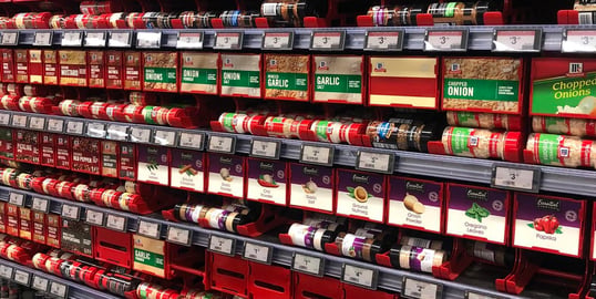 Grocery store shelf with electronic shelf labels displaying product prices of spices