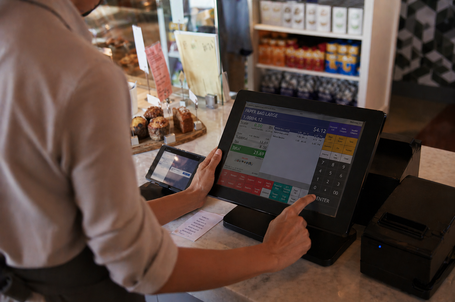 Retail employee using a touchscreen POS system to complete a transaction at a checkout counter