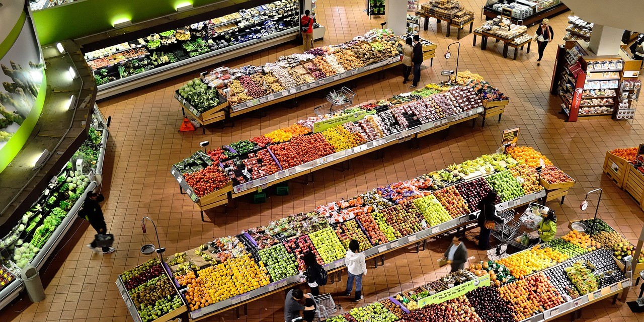 Elevated overview of a supermarkets produce section layout, showing customers shopping